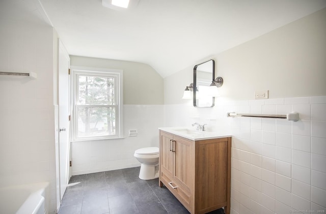 bathroom featuring tile walls, tile patterned flooring, vanity, toilet, and lofted ceiling