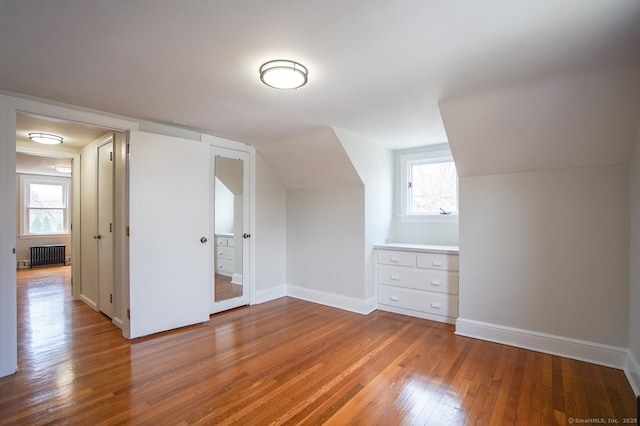 bonus room featuring baseboards, radiator, lofted ceiling, and hardwood / wood-style floors