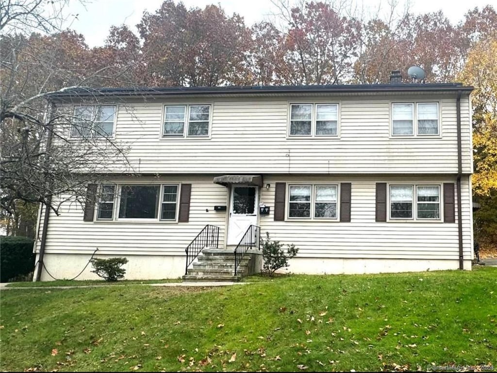 colonial-style house featuring a front yard
