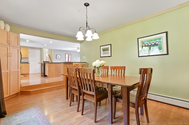 dining room with light wood-style flooring and an inviting chandelier