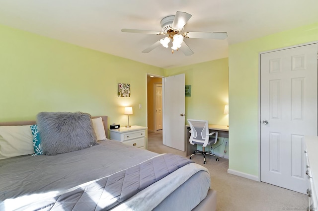 bedroom featuring light colored carpet, baseboards, and ceiling fan