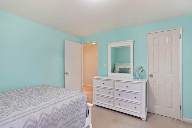 bedroom featuring light colored carpet and baseboards