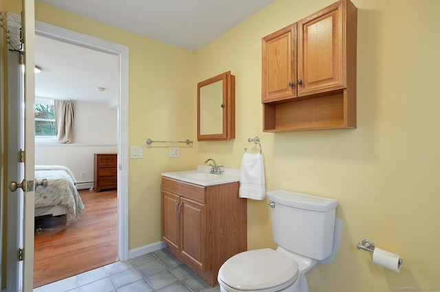 bathroom with vanity, ensuite bath, tile patterned flooring, toilet, and a baseboard radiator