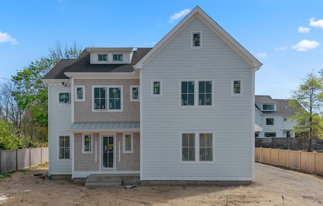 back of property featuring a shingled roof and fence