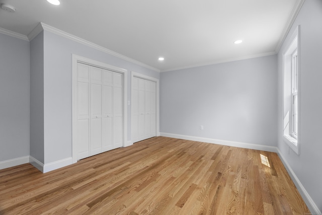 unfurnished bedroom with light wood finished floors, baseboards, recessed lighting, and multiple closets