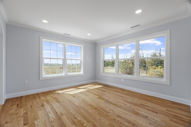 spare room with baseboards, recessed lighting, light wood-style flooring, crown molding, and visible vents