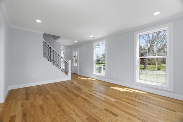 unfurnished living room featuring ornamental molding, baseboards, stairway, and recessed lighting