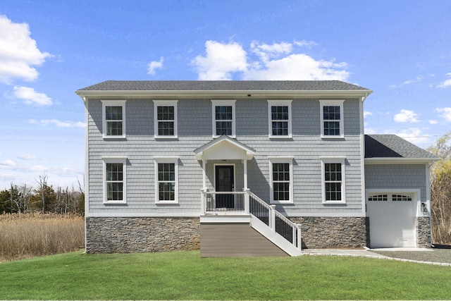 colonial home with a garage, stone siding, and a front yard