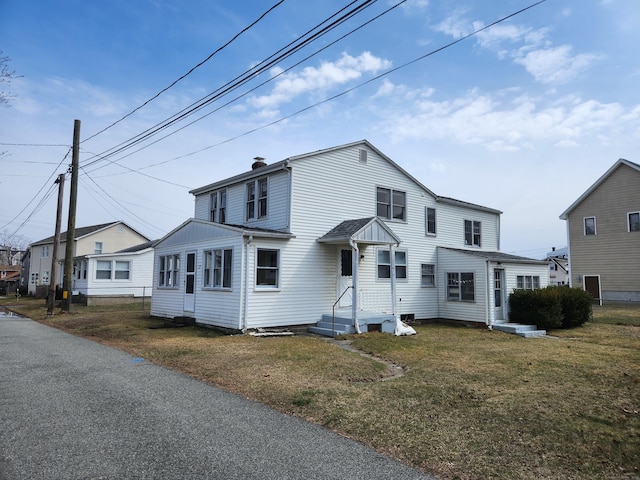 view of front of home featuring a chimney and a front lawn