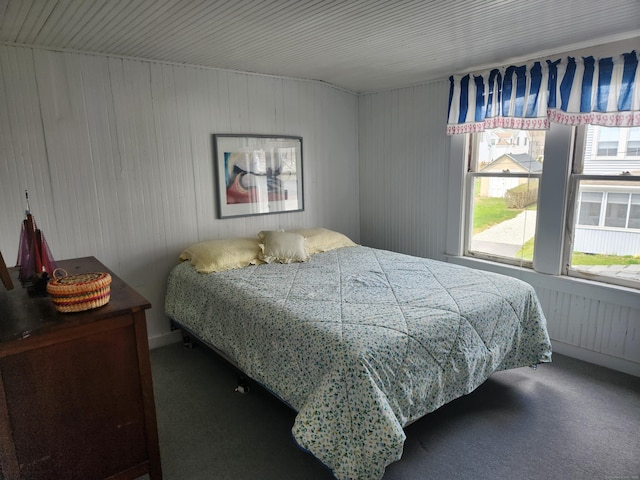 bedroom with wood walls and carpet floors