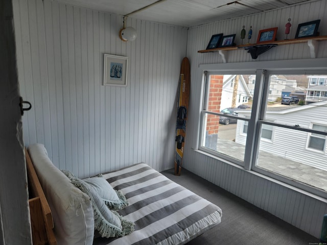 bedroom with wood walls and carpet floors