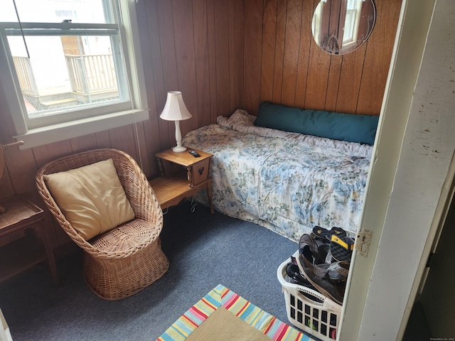 carpeted bedroom with wooden walls