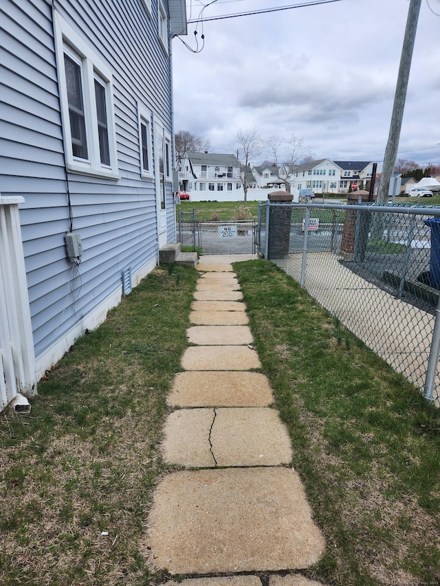 view of yard with fence, a residential view, and a gate