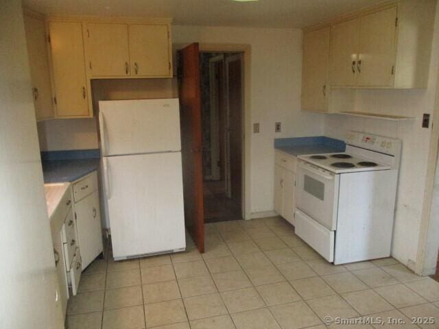 kitchen featuring light tile patterned floors and white appliances