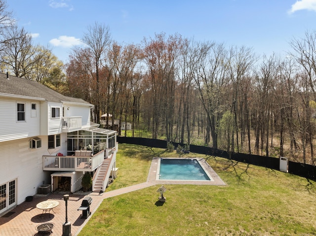 view of swimming pool featuring a yard, fence, a fenced in pool, a sunroom, and central AC