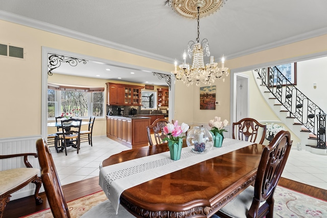 dining area with stairway, a chandelier, light tile patterned floors, ornamental molding, and visible vents