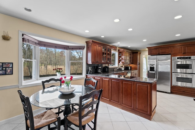 kitchen featuring glass insert cabinets, stainless steel appliances, recessed lighting, and a peninsula