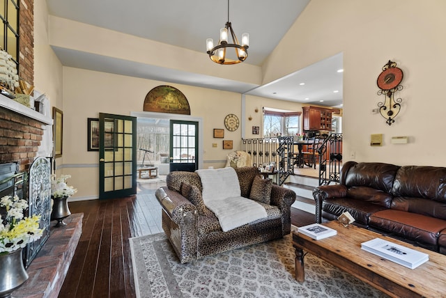 living area with recessed lighting, a chandelier, a fireplace, wood-type flooring, and baseboards