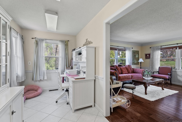 office space featuring a textured ceiling, plenty of natural light, and baseboards
