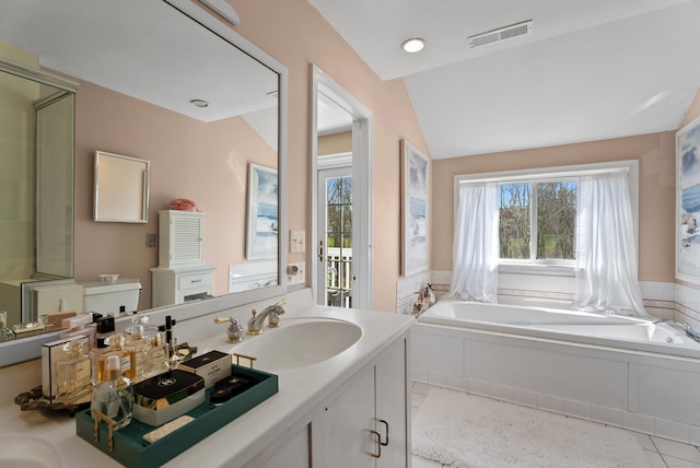 full bath with visible vents, vaulted ceiling, a garden tub, vanity, and tile patterned flooring