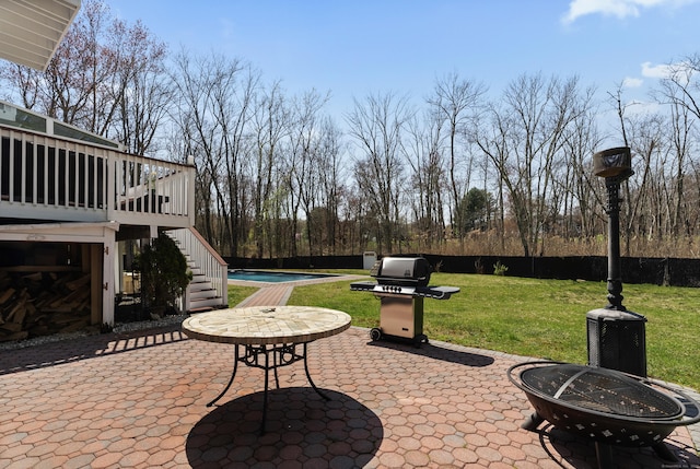 view of patio / terrace with a fire pit, stairs, a fenced in pool, a deck, and fence