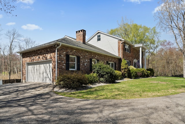 view of home's exterior featuring a chimney, aphalt driveway, a lawn, brick siding, and an attached garage