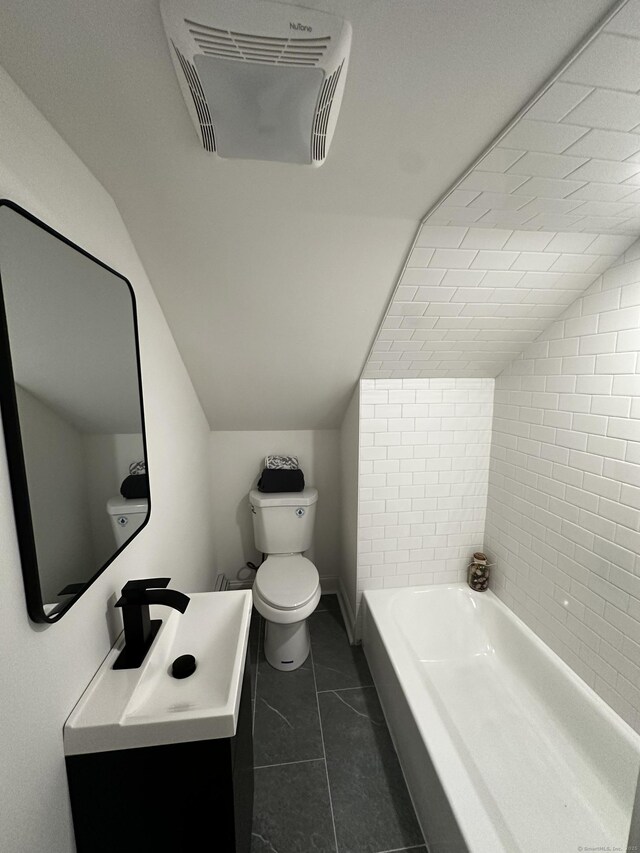 384 Sylvan Ave, Waterbury, CT 06706 - bathroom with toilet, lofted ceiling, a bathtub, vanity, and tile patterned flooring