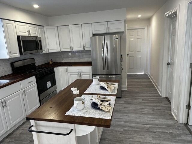 384 Sylvan Ave, Waterbury, CT 06706 - kitchen with butcher block countertops, stainless steel appliances, white cabinets, decorative backsplash, and recessed lighting