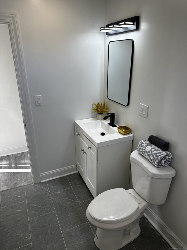 384 Sylvan Ave, Waterbury, CT 06706 - bathroom with vanity, toilet, baseboards, and tile patterned flooring