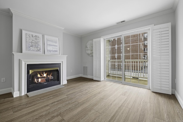 49 Glenbrook Rd Apt 209, Stamford, CT 06902 - unfurnished living room with crown molding, a lit fireplace, visible vents, wood finished floors, and baseboards