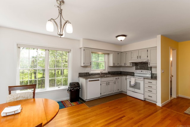 2 Cassella Dr, Wallingford, CT 06492 - kitchen featuring white appliances, dark countertops, under cabinet range hood, baseboards, and a sink