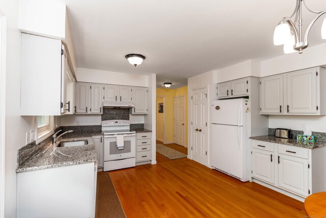 2 Cassella Dr, Wallingford, CT 06492 - kitchen featuring white appliances, light wood finished floors, under cabinet range hood, a sink, and dark stone counters
