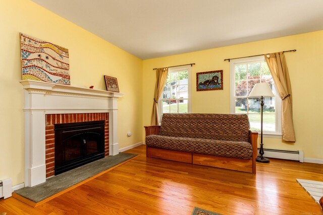 2 Cassella Dr, Wallingford, CT 06492 - living area featuring a baseboard heating unit, a fireplace, wood finished floors, and baseboards