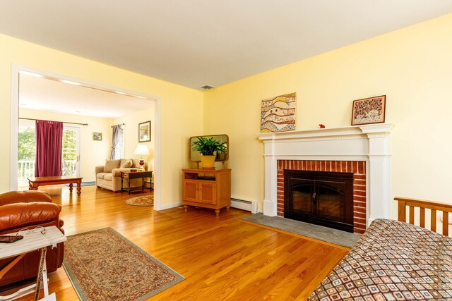 2 Cassella Dr, Wallingford, CT 06492 - living area with a baseboard heating unit, wood finished floors, and a fireplace