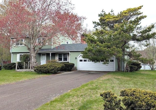 view of front facade featuring driveway, a chimney, a front lawn, and a garage
