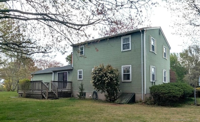 back of house featuring a yard and a deck