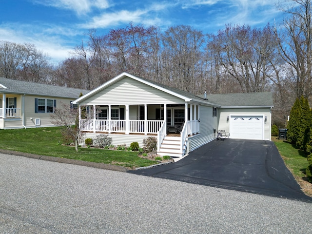 view of front of home featuring an attached garage, a front yard, roof with shingles, a porch, and driveway
