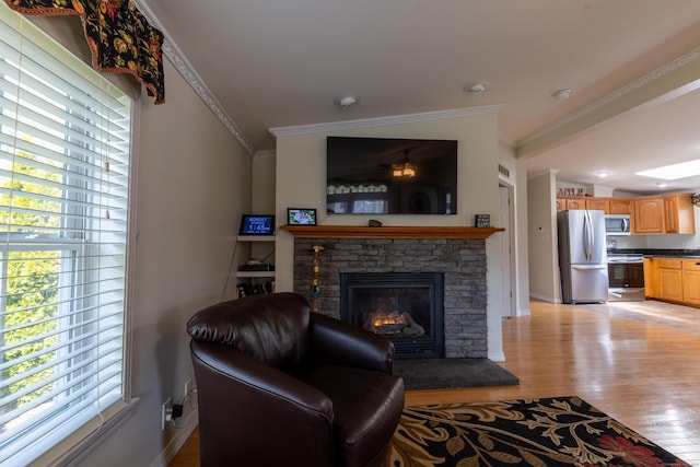 living area with crown molding, baseboards, a fireplace, and light wood-type flooring