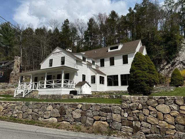 back of property featuring covered porch