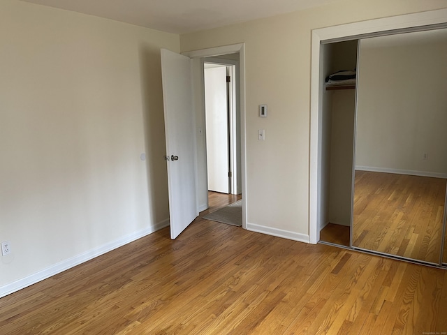 273 Queen St Apt 15E, Southington, CT 06489 - unfurnished bedroom with light wood-type flooring, a closet, and baseboards