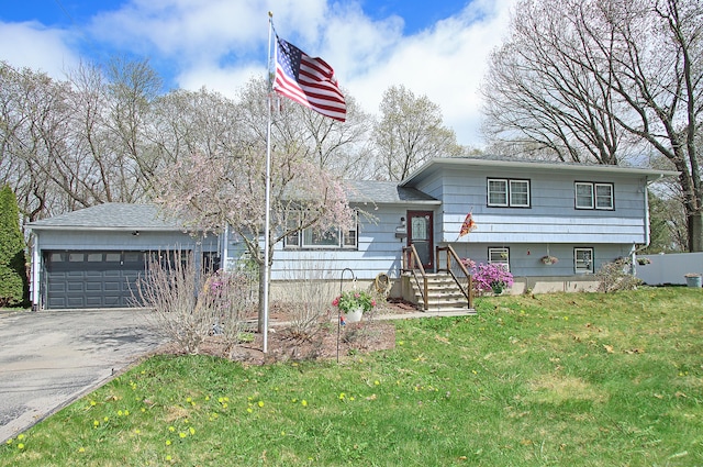 tri-level home featuring an attached garage, a front lawn, and aphalt driveway