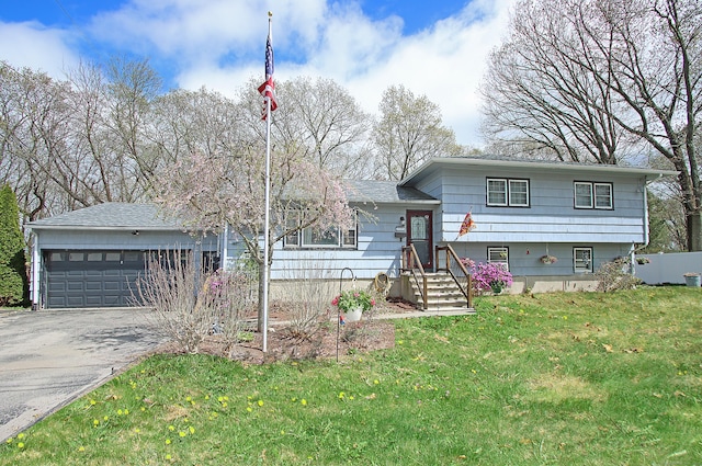 tri-level home with an attached garage, driveway, and a front yard
