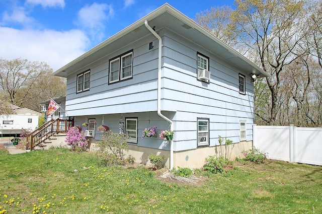 view of side of property featuring a lawn and fence