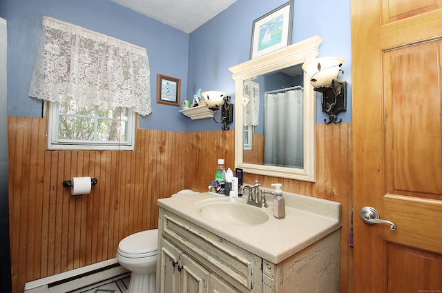 full bathroom featuring wooden walls, wainscoting, vanity, toilet, and a baseboard heating unit