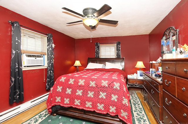 bedroom featuring a baseboard radiator, wood finished floors, multiple windows, and cooling unit