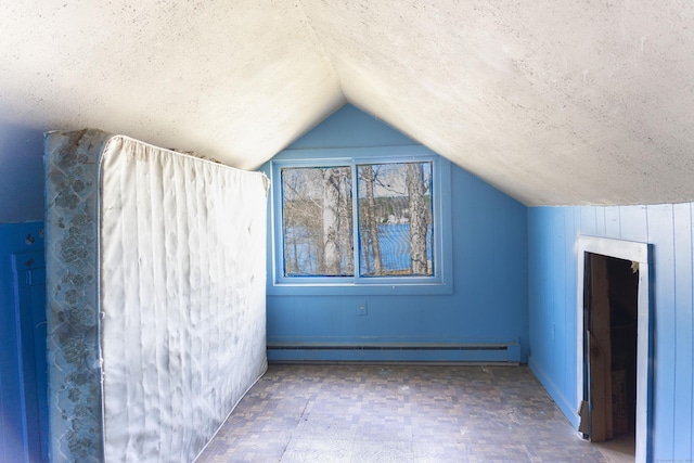 56 Laurel Hill Dr, Woodstock, CT 06282 - additional living space with vaulted ceiling, baseboard heating, a textured ceiling, and tile patterned floors