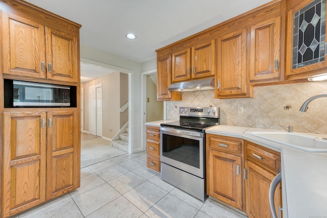 18 Black Birch Rd, Plainville, CT 06062 - kitchen with appliances with stainless steel finishes, under cabinet range hood, tasteful backsplash, light countertops, and brown cabinetry