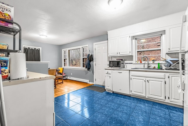 kitchen with stainless steel microwave, a healthy amount of sunlight, white dishwasher, and a sink
