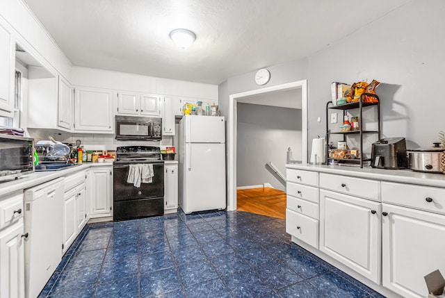 kitchen featuring light countertops, white cabinetry, black appliances, and tasteful backsplash