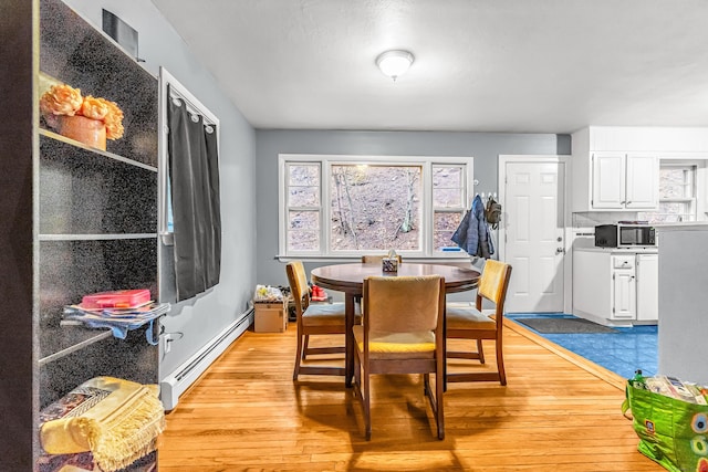 dining area featuring a baseboard radiator and light wood-type flooring